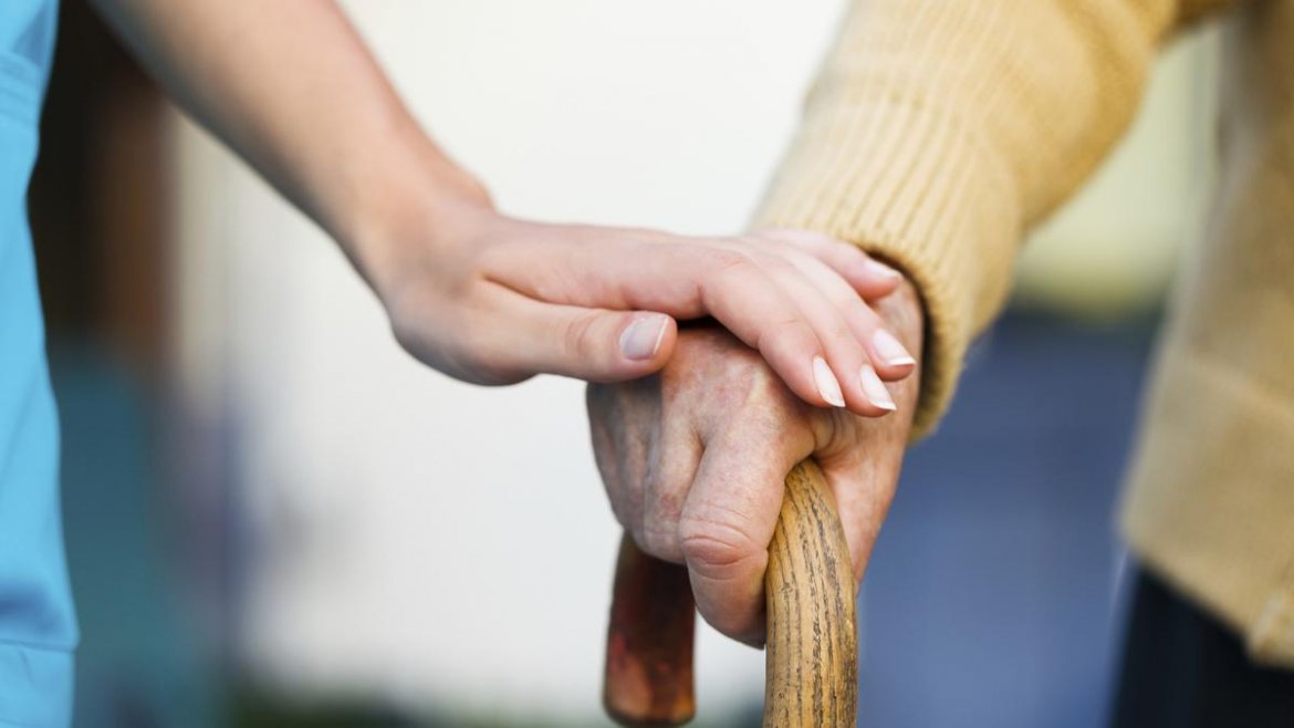 Assistenza verso anziano Mano di una donna che accarezza mano di un anziano