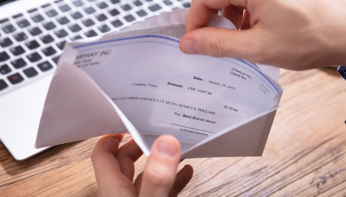 Persona davanti a tastiera pc apre busta paga