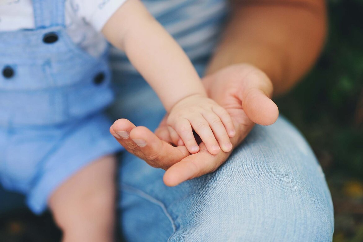 Genitore tiene mano bambino