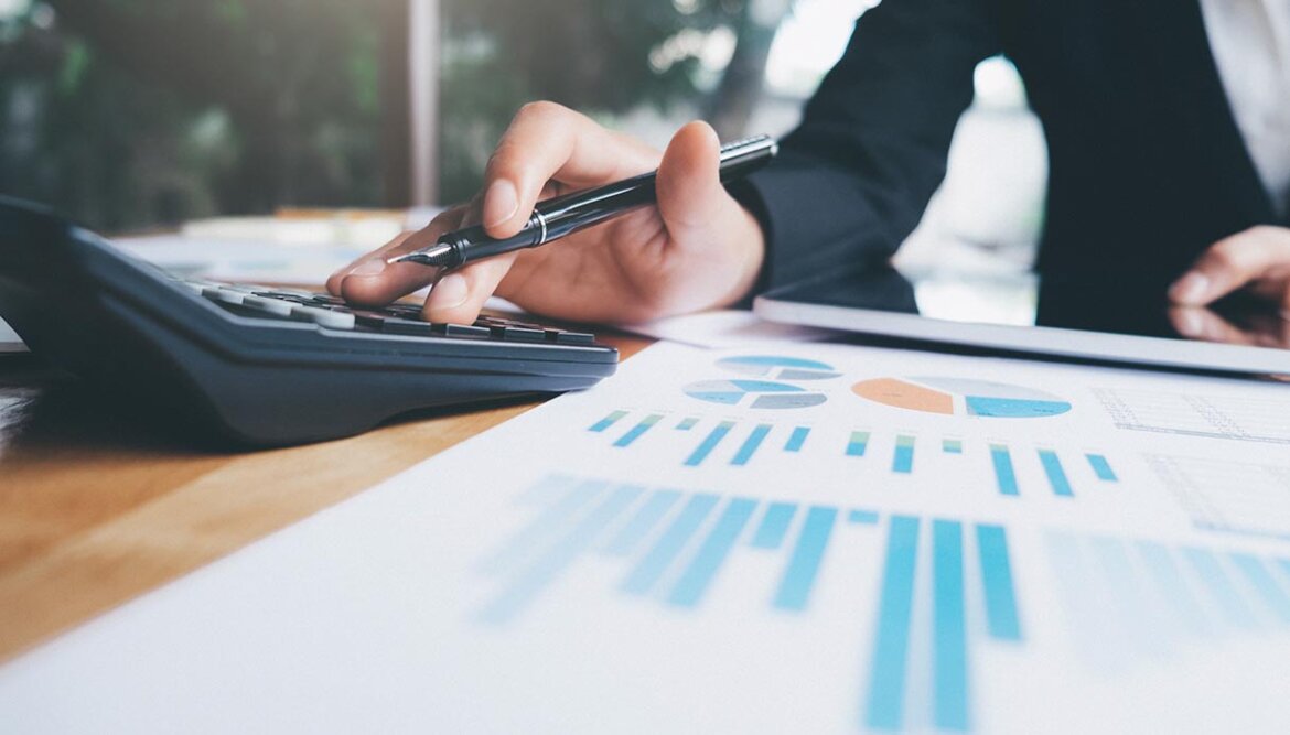 Persona in ufficio fa i conti con la calcolatrice