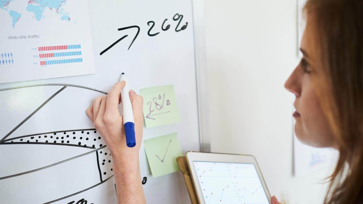 Donna scrive e calcola percentuali su un tabellone