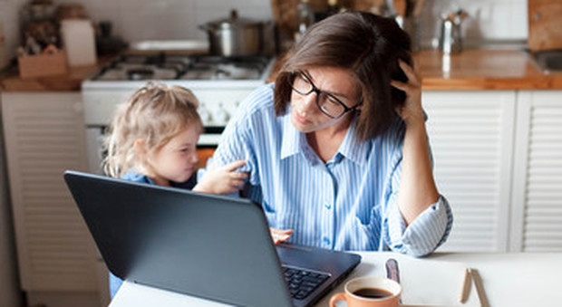 Mamma a lavoro in smart working con bimba vicino