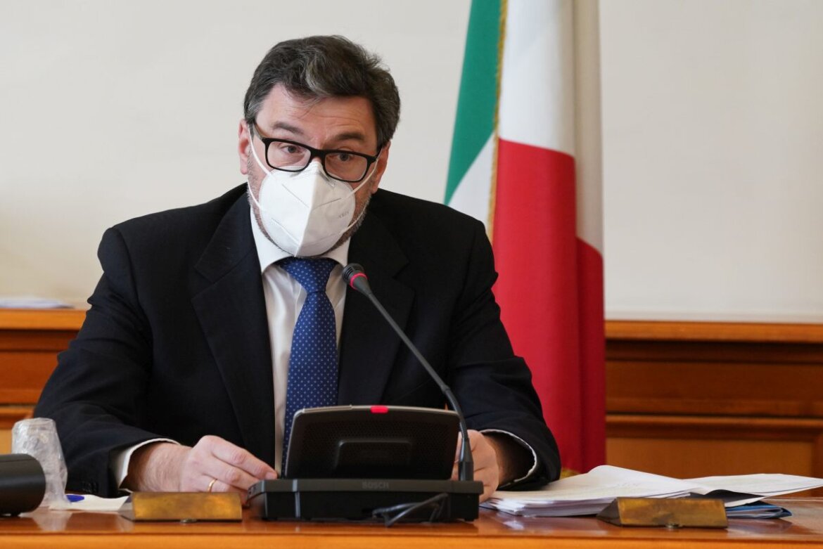 Giancarlo Giorgetti Il ministro Giorgetti con la mascherina davanti al Tricolore