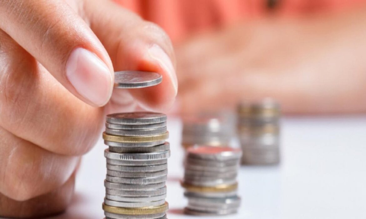 Persona impila soldi a moneta.