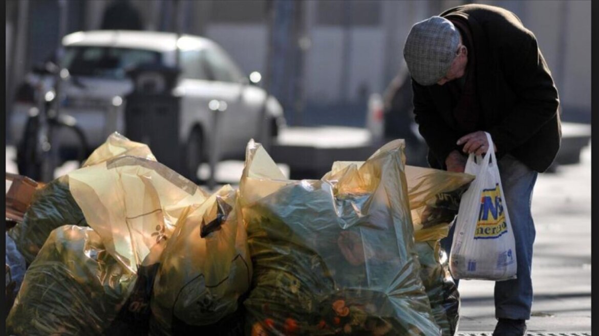 Persona anziana con grosse difficoltà economiche raccoglie cibo dalla spazzatura