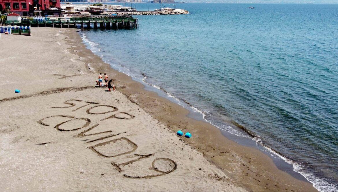 Spiaggia con scritta che recita: "Stop covid-19"