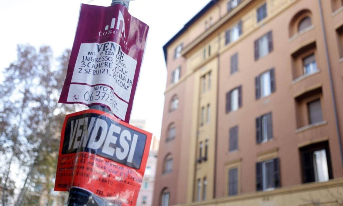 Mercato immobiliare Appartamento nel sottofondo con cartelli "vendesi" attaccati ad un palo della luce