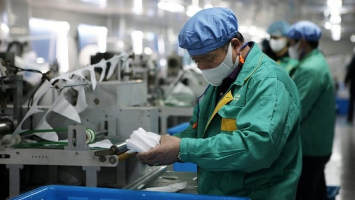 Operai a lavoro indossano dispositivi di sicurezza contro il coronavirus