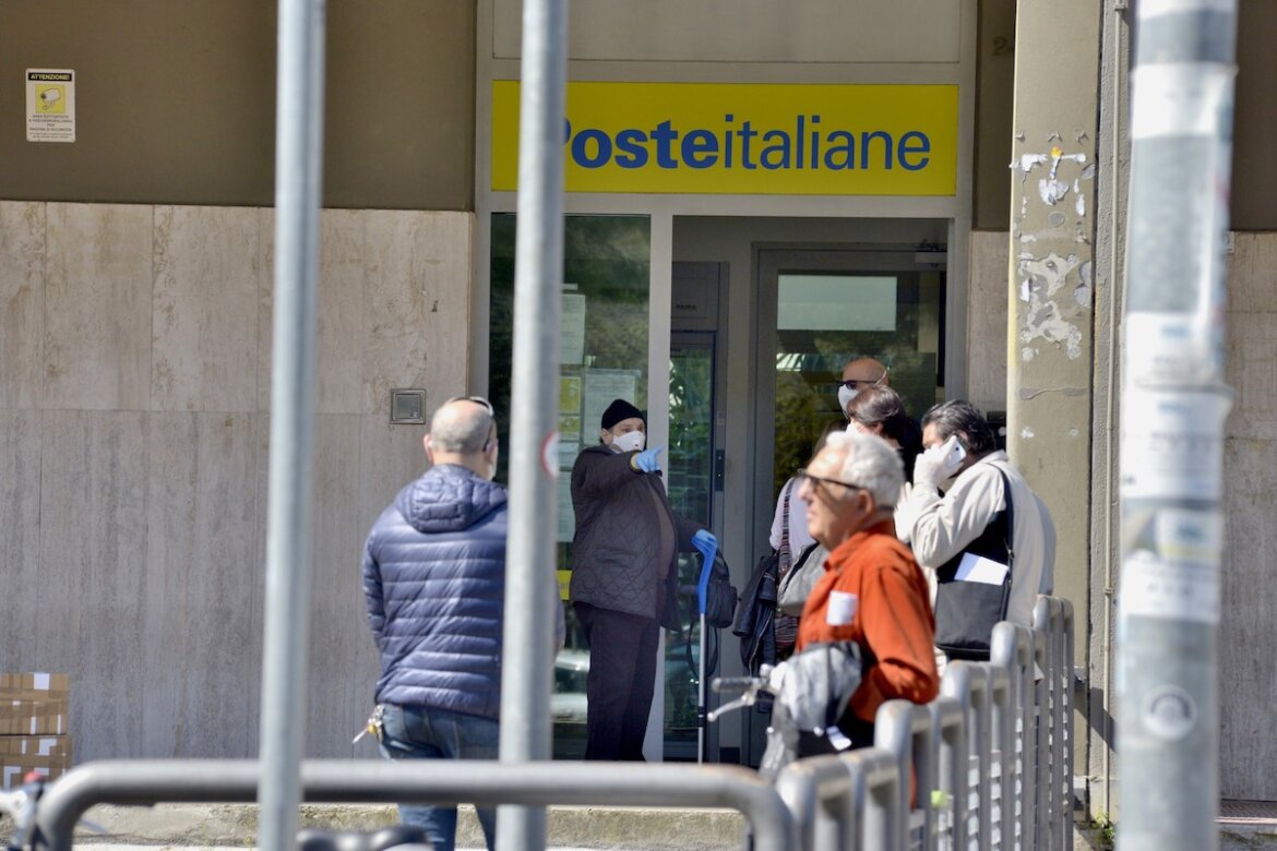 Gente in fila davanti ad un ufficio postale in una foto