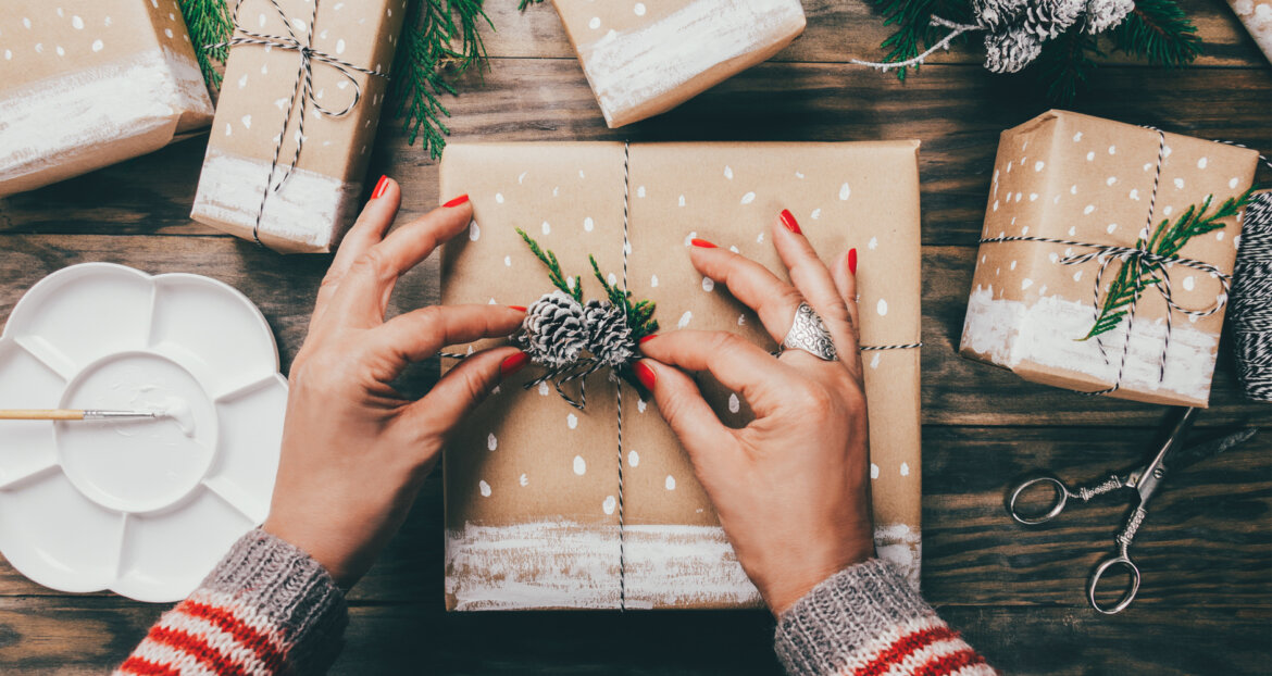 Donna impacchetta regalo in una foto Donna prepara regalo di Natale in una foto