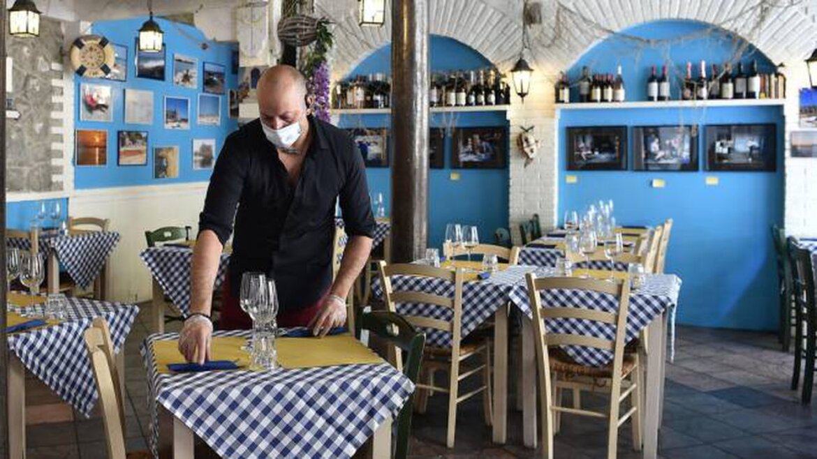 Riapertureattività all’aperto Ristoratore prepara tavolo