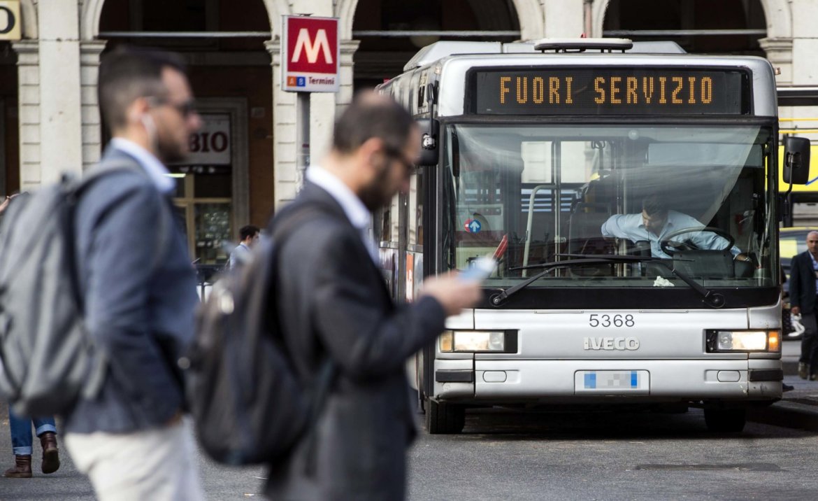 Persone in città con bus e segnaletica metro sullo sfondo