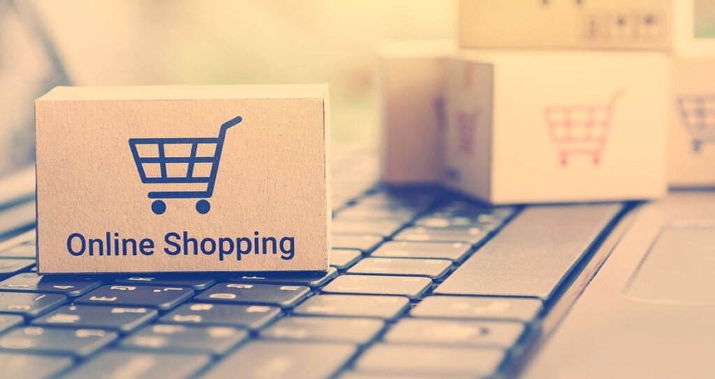 Computer con sopra scatoletta con la scritta "Shopping online"