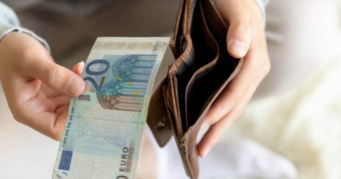 Persona con 20 euro in mano e portafogli vuoto