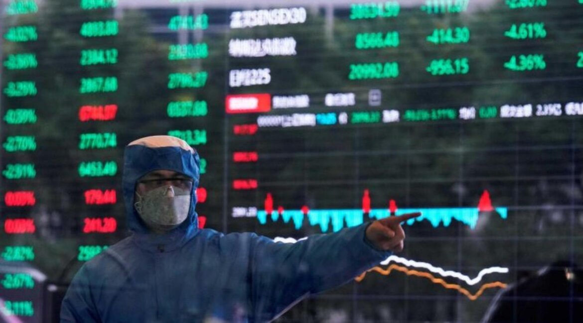 Medico con dpi al lavoro. Alle sue spalle grafico con dati