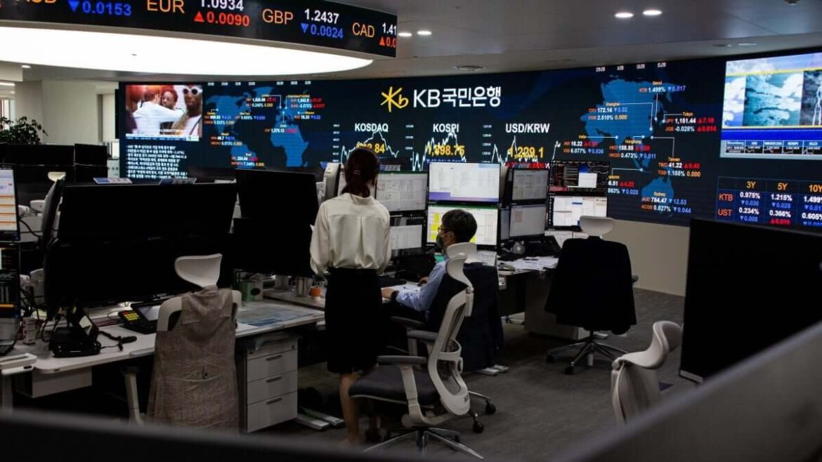 economisti al lavoro al pc Uomo e donna al lavoro in ufficio su andamento economia