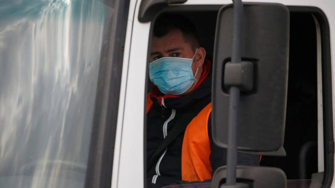 camionista con mascherina mentre guida