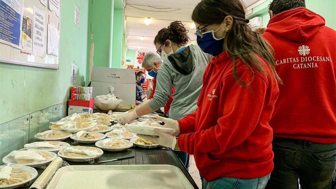 Volontari al lavoro alla Caritas offrono pasti caldi ai poveri