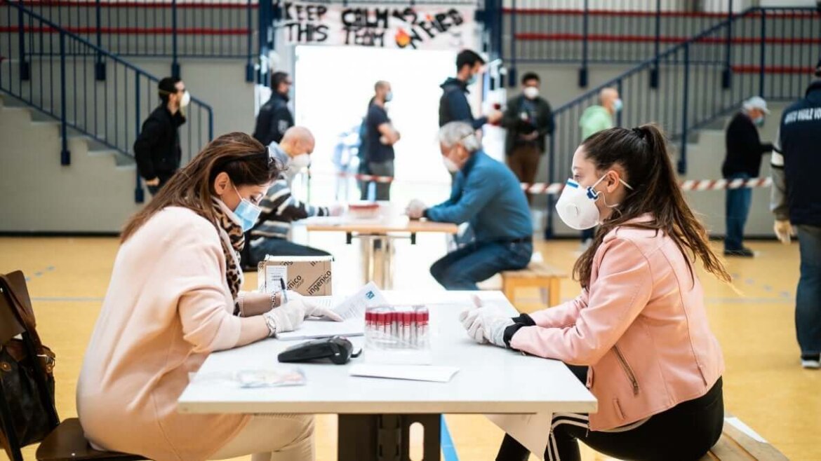 contagi foto Persone sedute al tavolo con mascherine