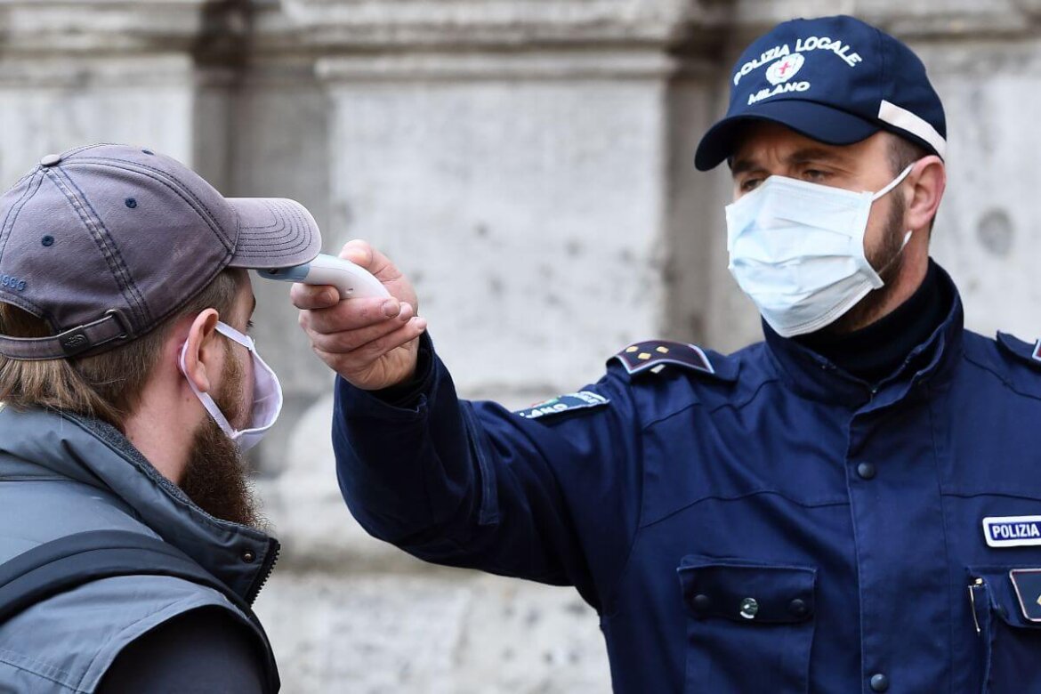 controlli Agente di polizia che misura temperatura a uomo con mascherina