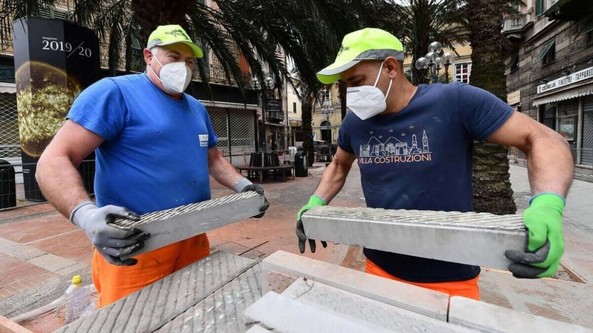 Operai con mascherina mentre lavorano in fabbrica Operai con mascherina al lavoro