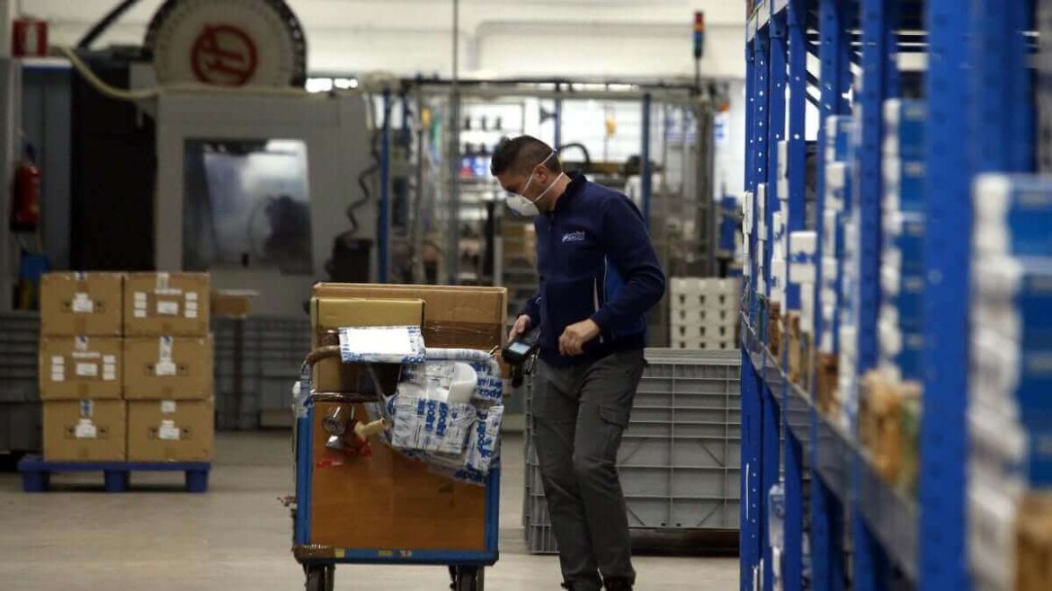 Operaio con mascherina al lavoro in fabbrica Operaio con mascherina mentre lavora in fabbrica