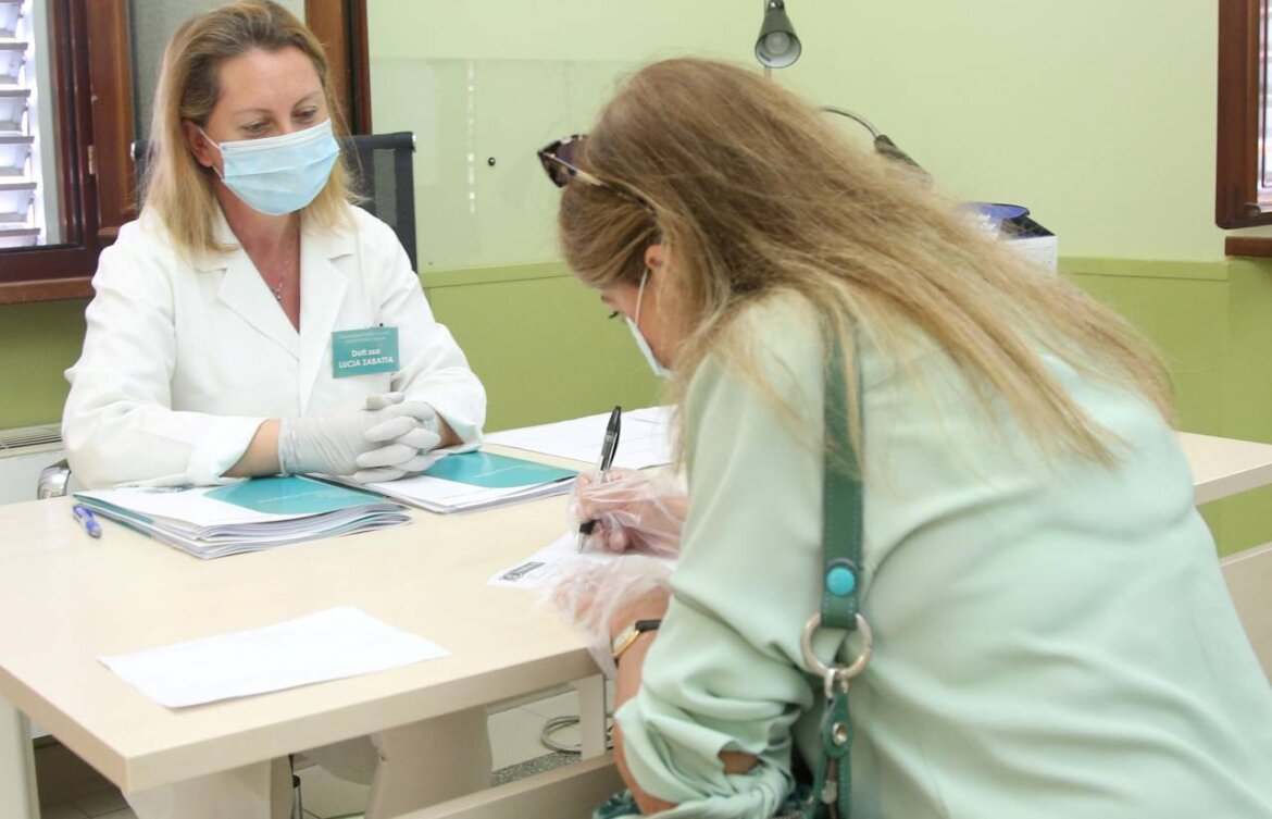 Donna con mascherina firma documento in una foto