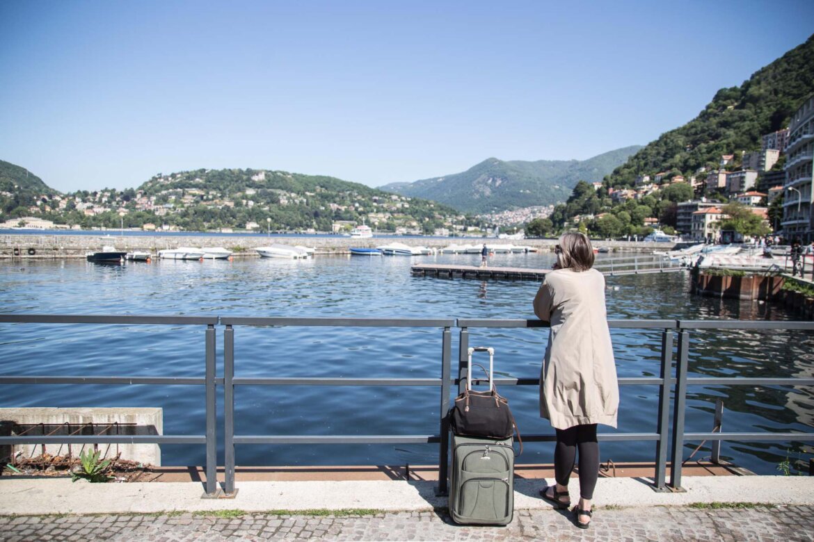 Signora con valigia osserva il mare Turista osserva il mare in una foto