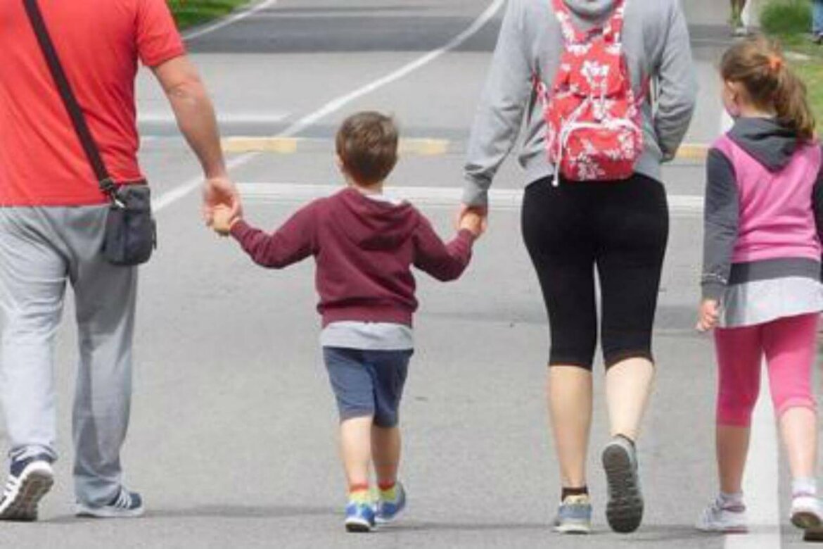 famiglia mamma e papà che tengono figlio per mano