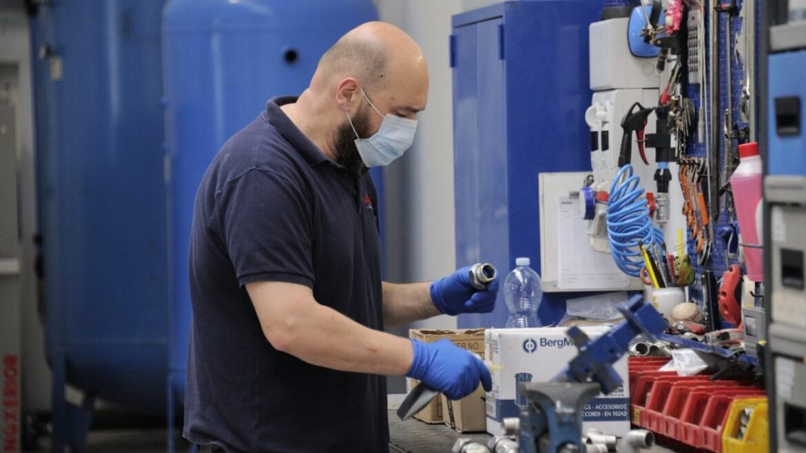 Operaio al lavoro in fabbrica alle prese con un macchinario
