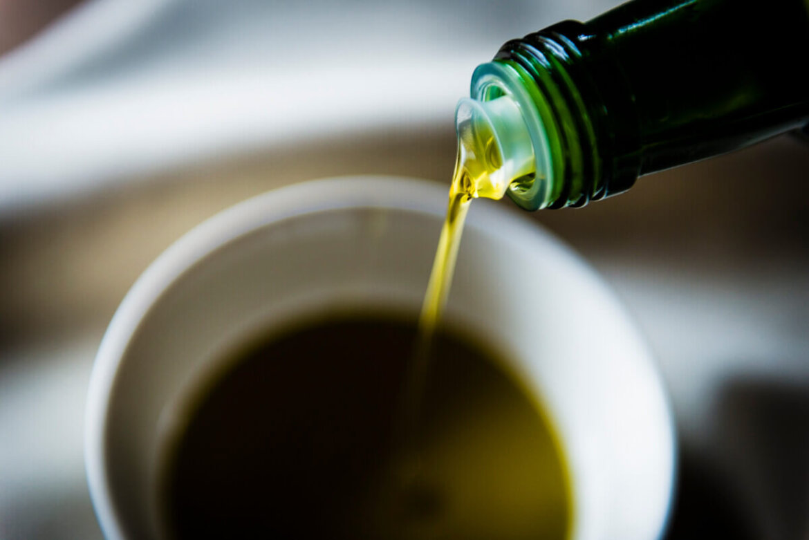 Olio d'oliva versato in un recipiente da bottiglia