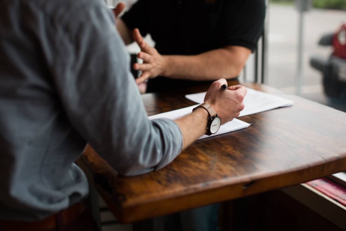 Uomini che parlano seduti ad un tavolo Due uomini discutono su un accordo lavorativo