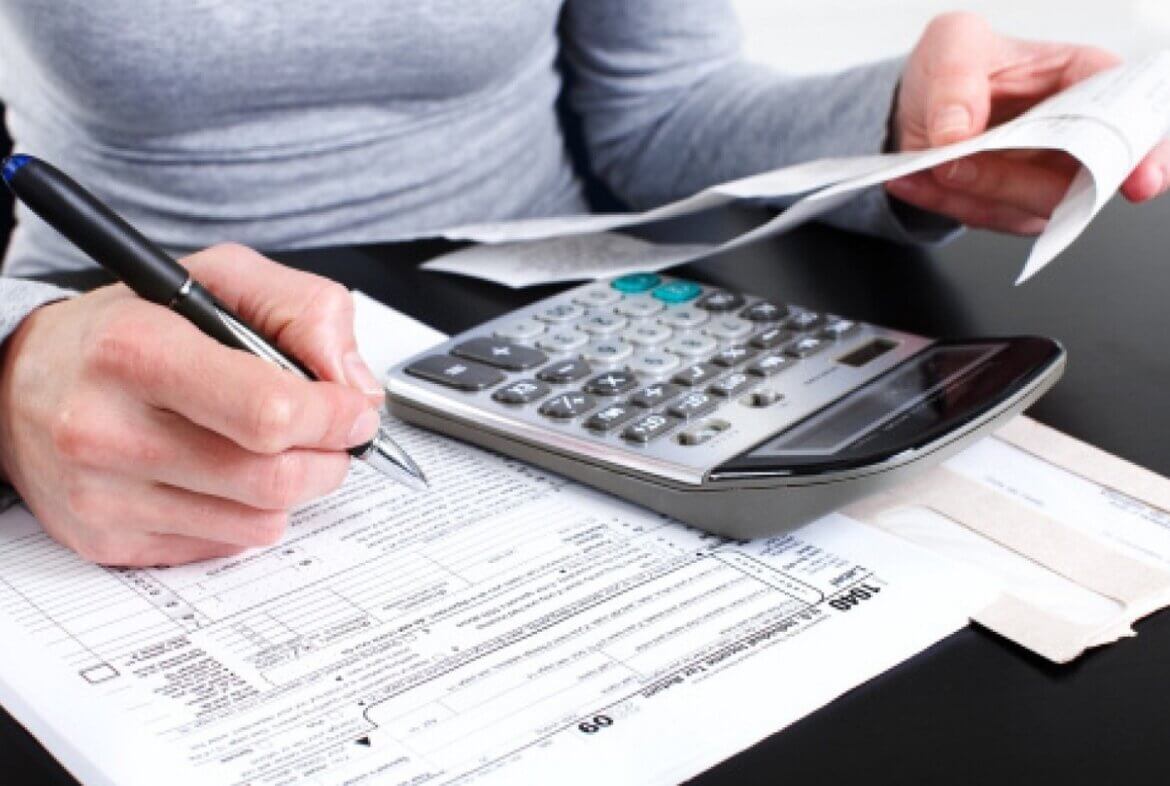 Donna effettua calcoli in una foto Donna confronta numeri con calcolatrice e documenti