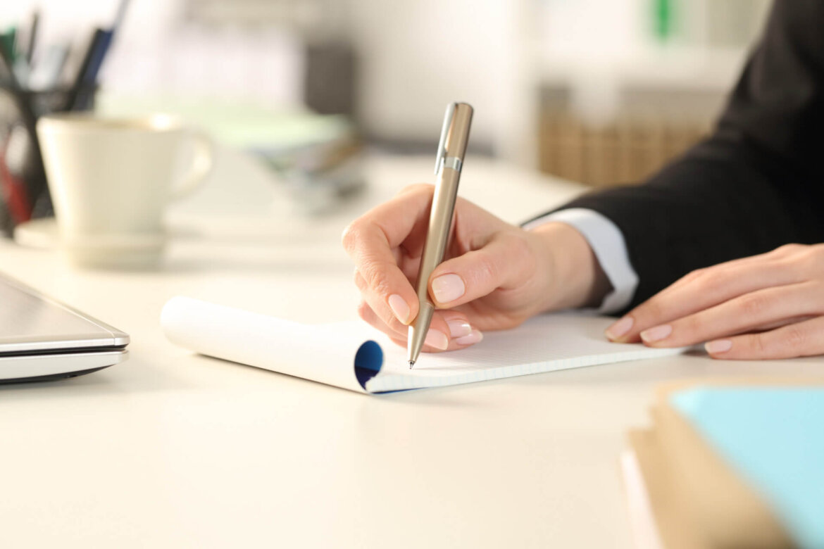 uomo che scrive su foglio