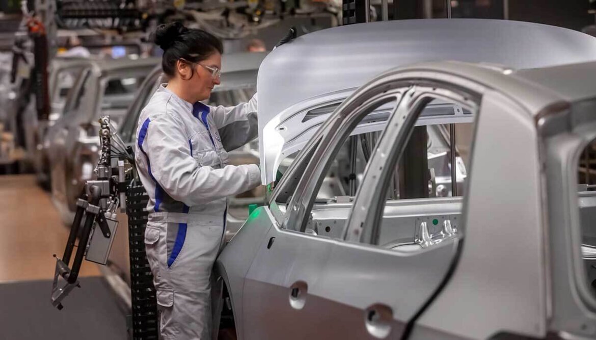 Operaia alle prese con macchinario in fabbrica