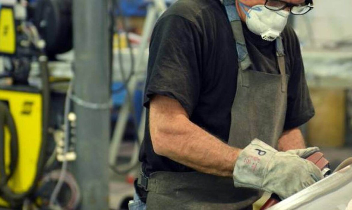 Operaio alle prese con macchinario in fabbrica