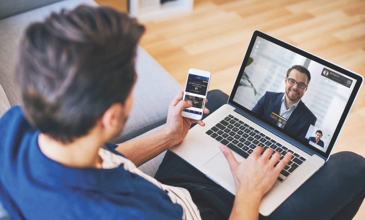 Uomo al pc con smartphone in mano