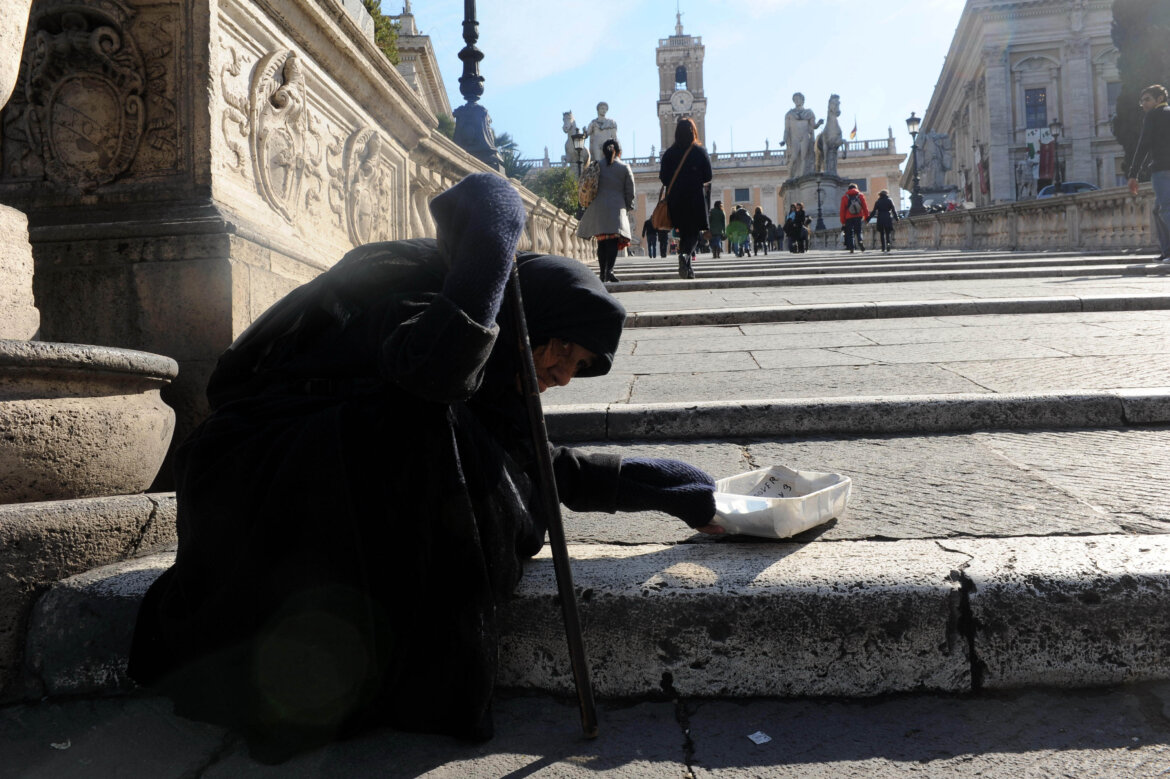 Anziana signora chiede elemosina in una foto Anziana signora seduta per terra chiede elemosina