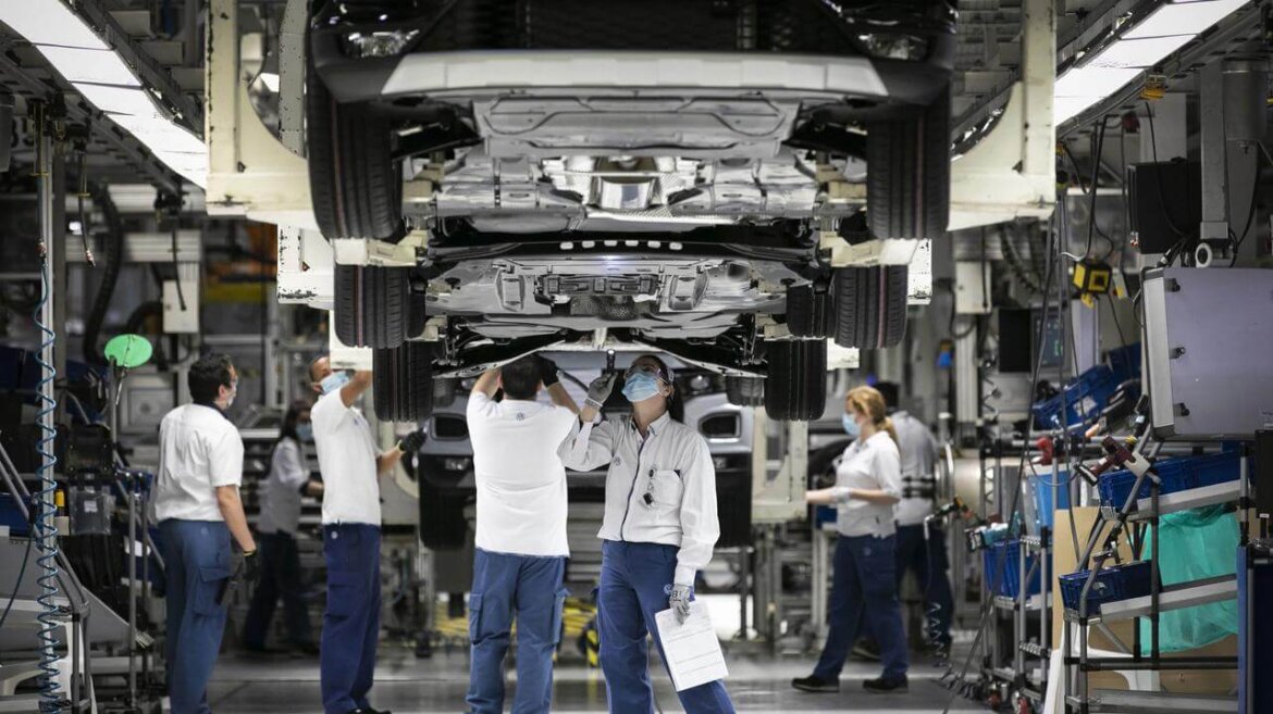 Operai che lavorano su macchina in fabbrica