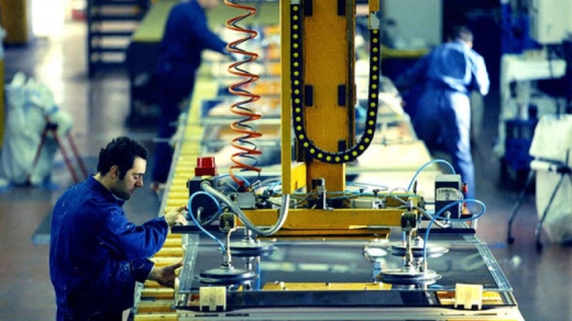 Operai al lavoro in fabbrica Operai alle prese con macchinario in fabbrica