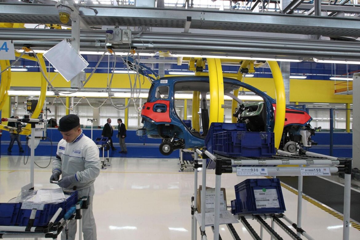 Operaio al lavoro in fabbrica davanti ad un macchinario