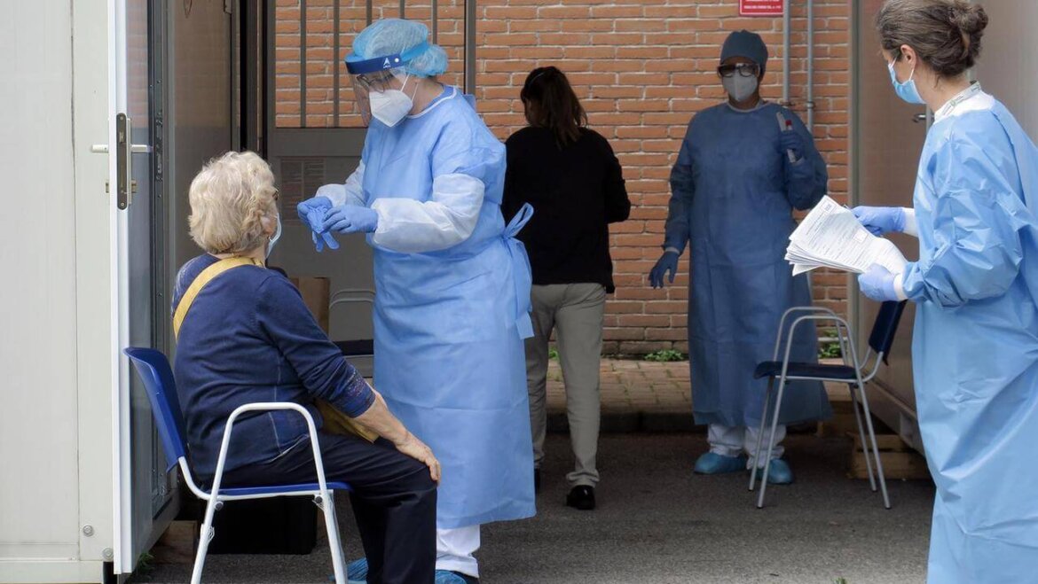 medico con dpi mentre visita una signora