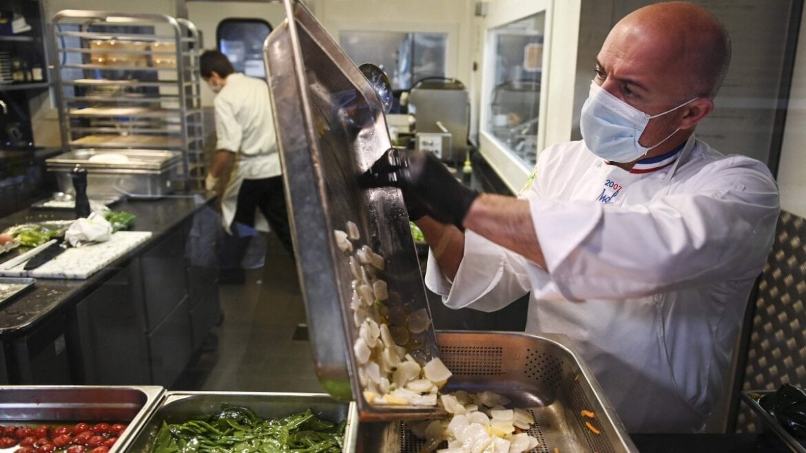 Cuoco con mascherina al lavoro in cucina