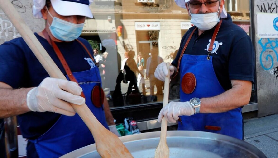 Due uomini cucinano con mascherina chirurgica