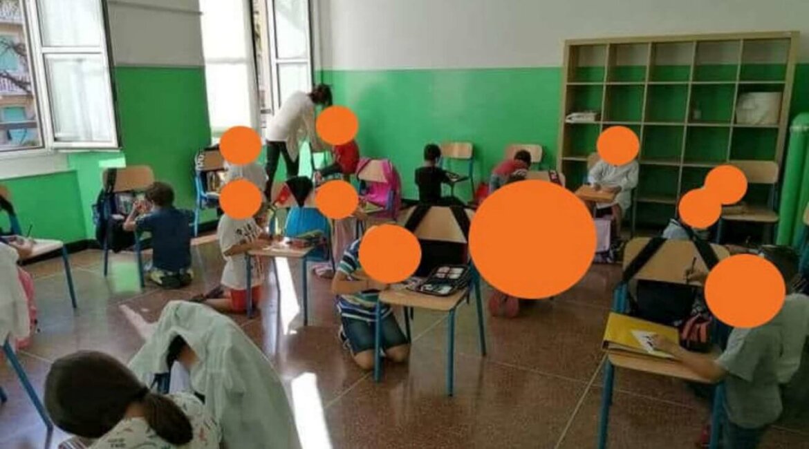 Bambini con volto oscurato in ginocchio in classe