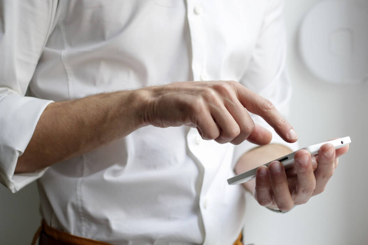 Persona che fa calcoli Persona che pigia tasti su telefono