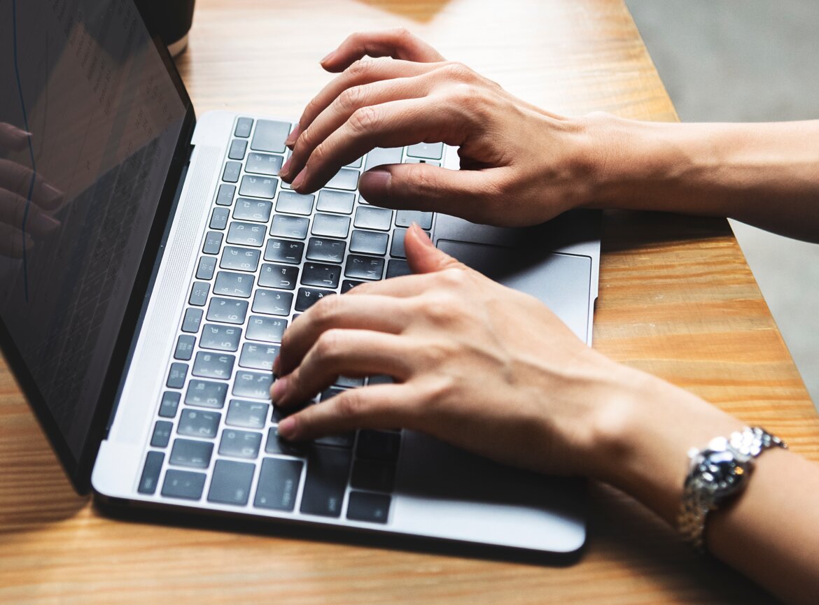 Persona al lavoro su scrivania con pc Persona al lavoro su scrivania con pc in una foto