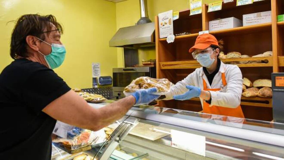 uomo con mascherina mentre fa la spesa al supermercato