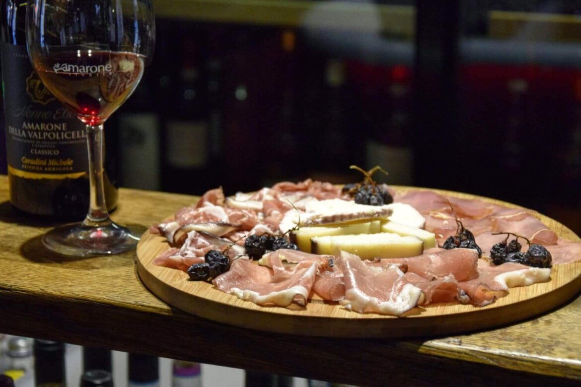 Tagliere di salumi e formaggi con bicchiere di vino
