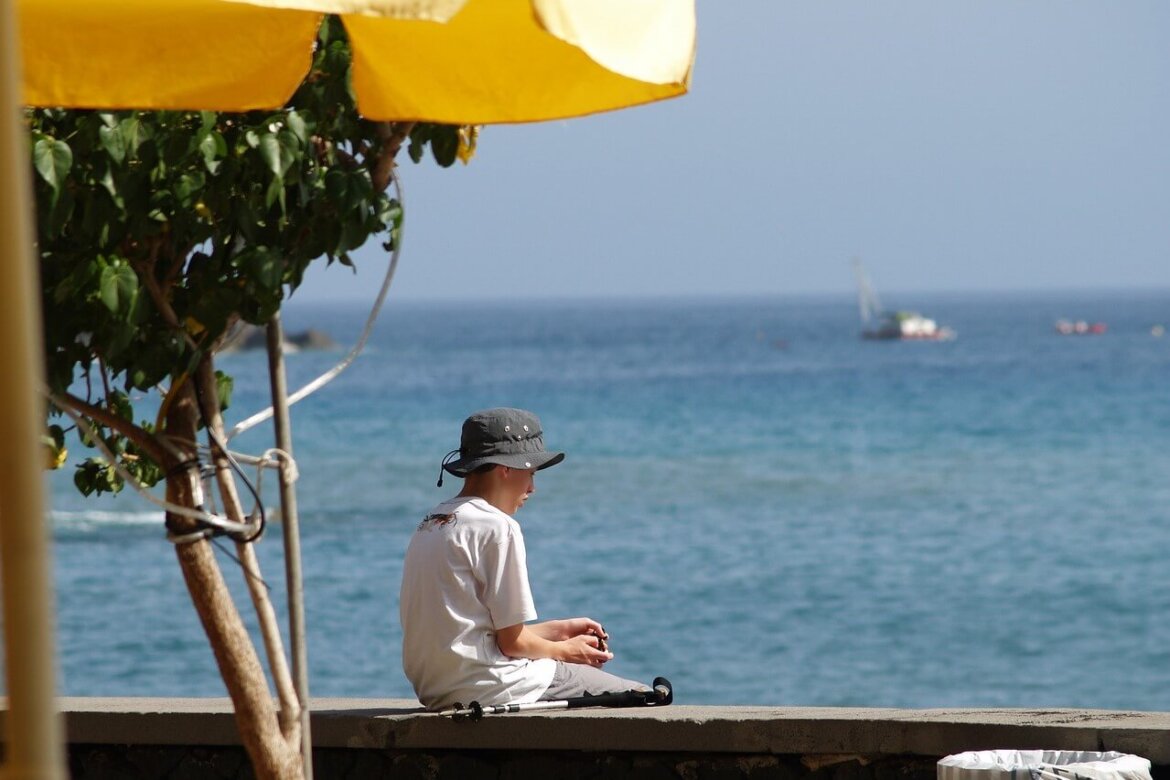 Bambino con cappello che prende il sole